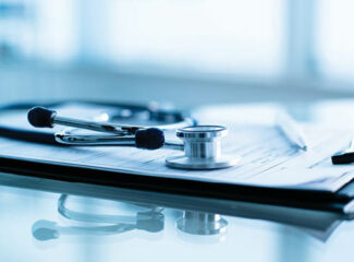 Paperwork with medical equipment laid ontop.