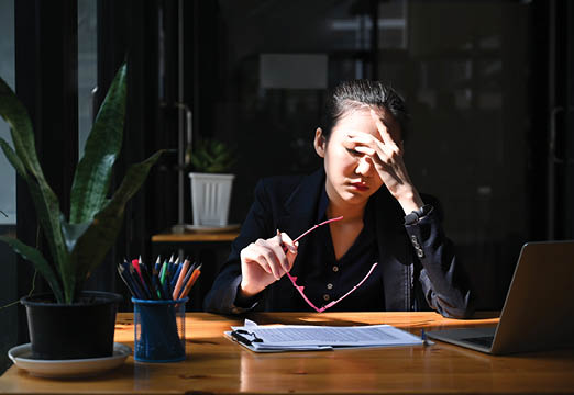 A woman office worker pinching her nose expressing stress