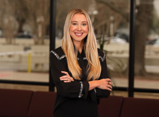Hannah Robinson in a black suit smiling for a professional photo